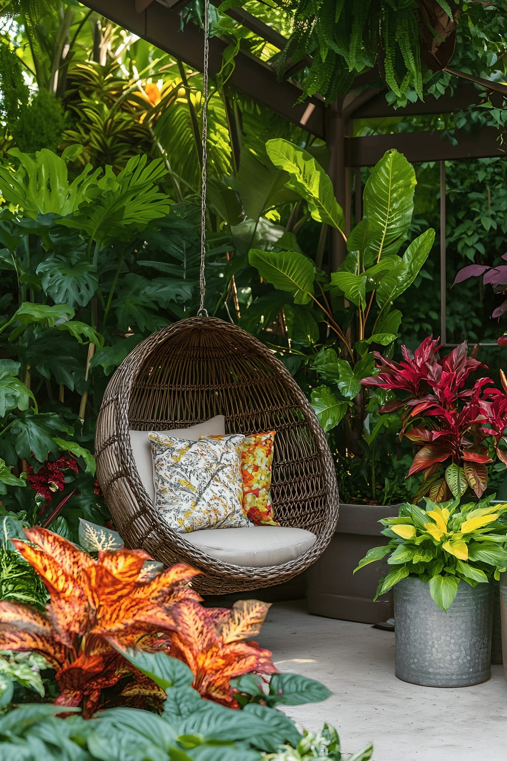 A small garden scene with a hanging wicker chair, a colorful array of croton plants, and a galvanized metal container filled with herbs. The entire space is designed with low-maintenance and budget-friendly elements.