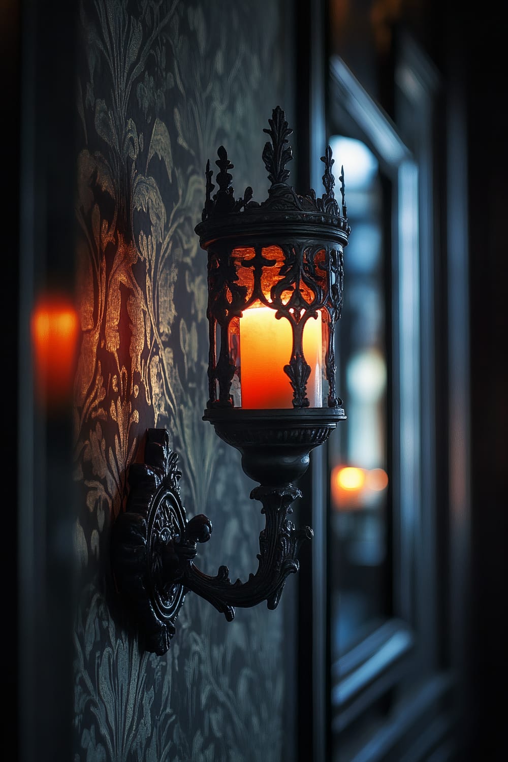 A closeup of an ornate wall sconce with an intricate wrought-iron design, holding a lit candle with an eerie glow. The sconce is mounted on a wall with rich, dark wallpaper adorned with elegant floral patterns. The warm light from the candle casts intricate shadows, enhancing the luxurious and moody ambiance of the space.