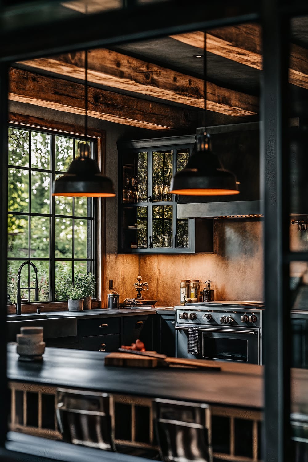 A moody farmhouse kitchen viewed through a large industrial-style window, featuring dark espresso cabinets, blackened steel countertops, and a combination of natural and artificial lighting. Exposed wooden beams adorn the ceiling, and there are pendant lights with dark metal shades above the kitchen island.