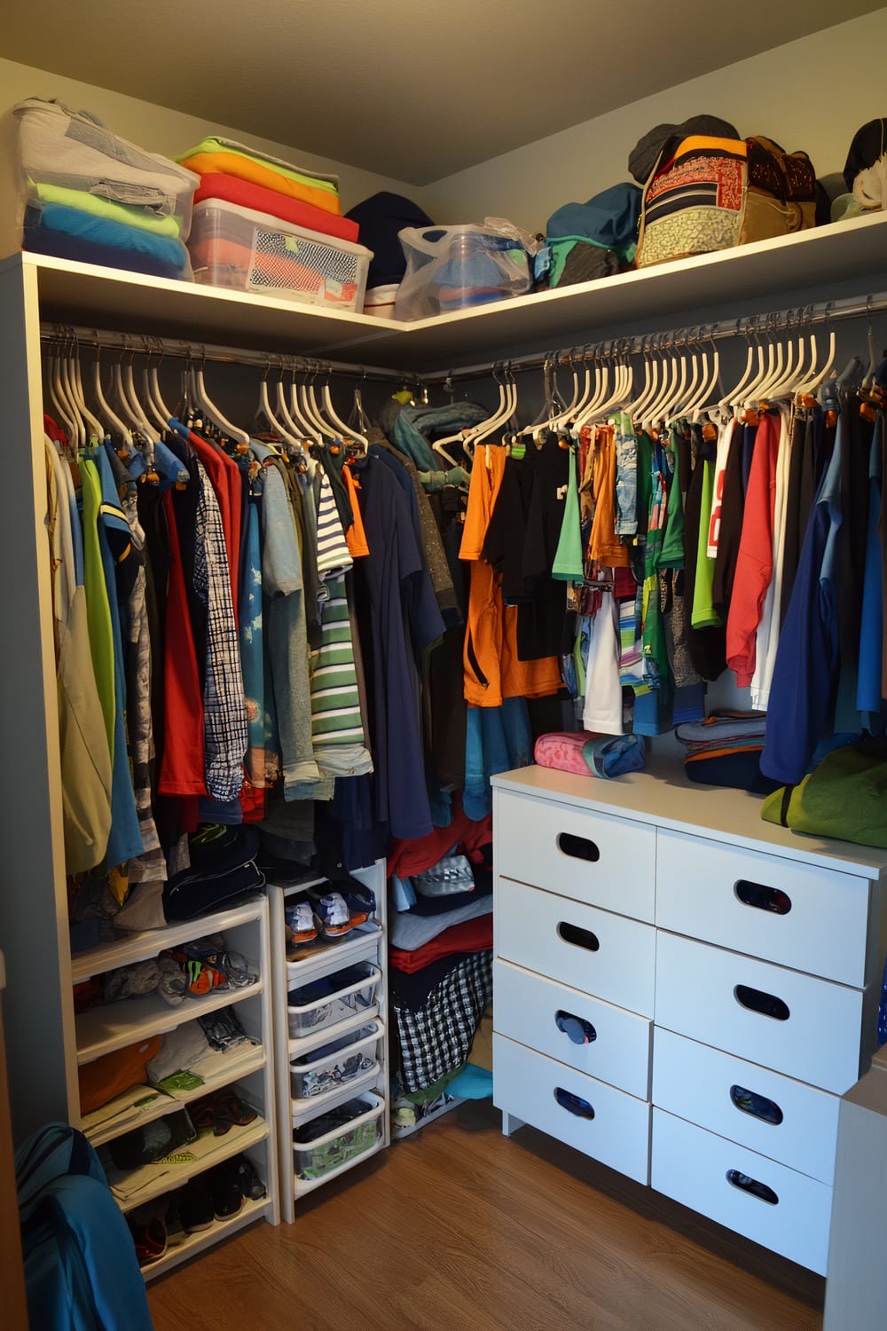 A gender-neutral pre-teen closet with neatly arranged clothes on rods, labeled storage bins above, pull-out drawers with interchangeable labels in a central shelving unit, and a small standing mirror. Hooks are visible for sports gear and backpacks.