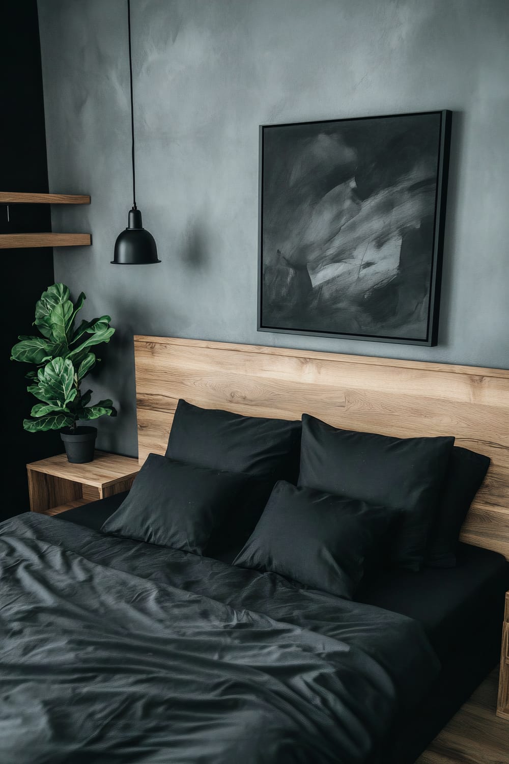 A modern minimalist bedroom with a black and wood color scheme. The room features a black platform bed with a wooden headboard, dressed in black bedding. On each side of the bed are wooden nightstands, each with a black table lamp. Mounted above the bed on a soft grey wall is a black and white abstract painting. To the left is a wooden shelf with a potted fiddle leaf fig plant. There is also a black pendant lamp hanging from the ceiling.