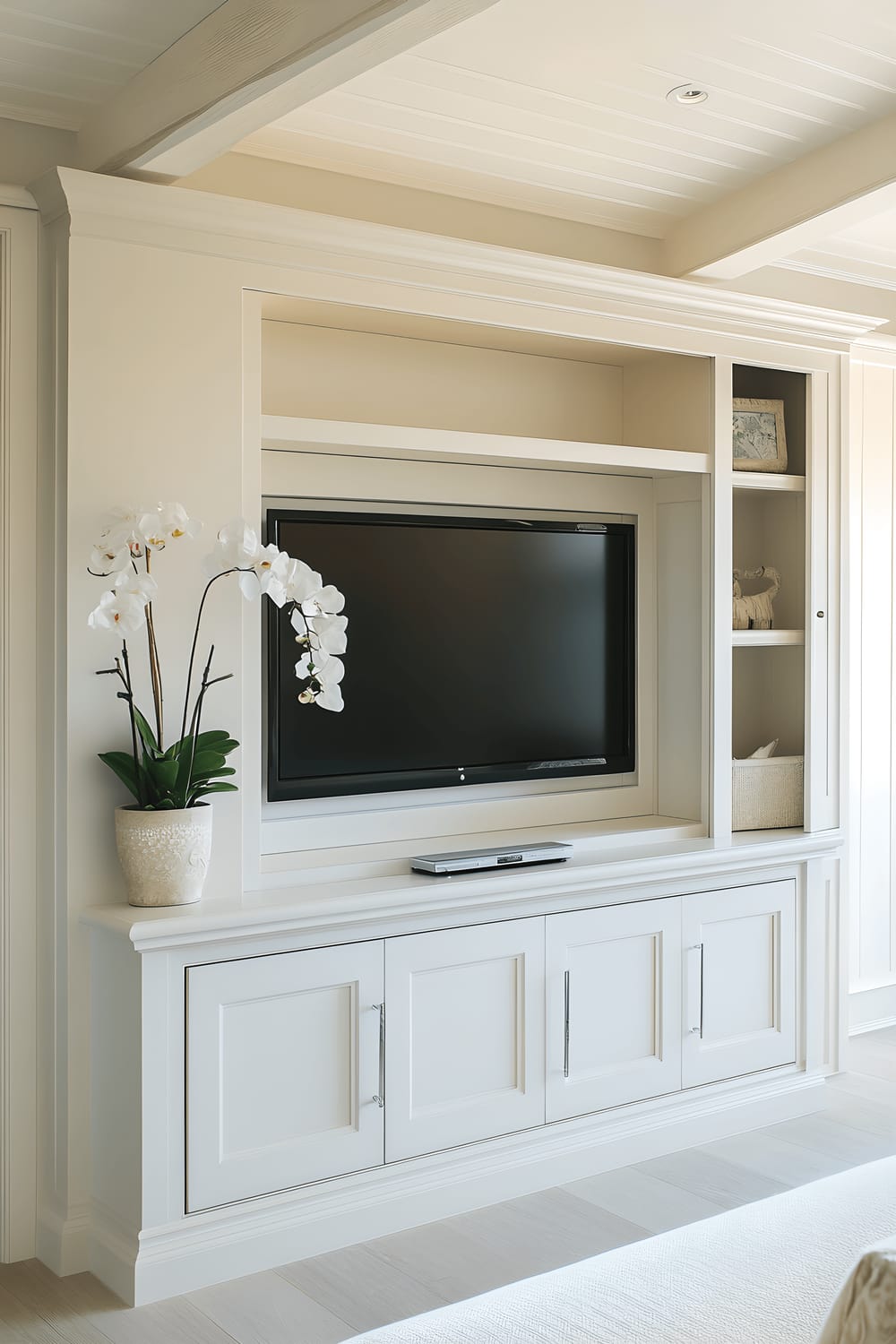 A modern living room featuring a wall dedicated to a large flat-screen TV positioned in sleek, dark cabinetry with concealed storage components. Soothing, ambient lights embedded in the cabinetry subtly illuminate the TV area, enhancing the overall clean and organized appearance of the place.