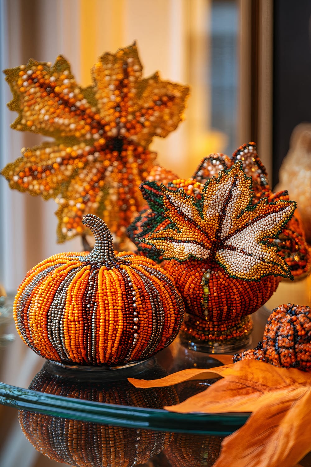 An elegant coffee table displays a collection of handcrafted beadwork figurines depicting fall leaves and pumpkins. These colorful creations are vibrantly illuminated by bold lighting against a subdued background, emphasizing the intricate details of the beads. The scene exudes an autumnal atmosphere, ideal for seasonal décor.