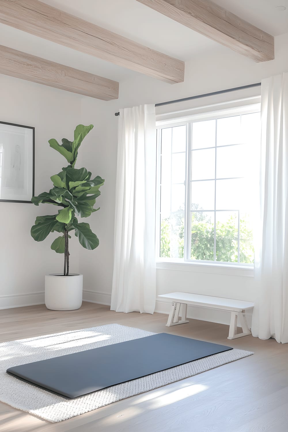 A bright and airy home gym featuring light wood flooring and white walls accented by light oak beams. In the center, a black yoga mat is spread out on a gray rug, with a set of white dumbbells on a wooden rack nearby. The room is lit by large windows draped with sheer white curtains, and a tall potted fiddle leaf fig plant stands next to them. One wall hosts a white shelf decorated with fitness magazines and a motivational quote in a black frame.